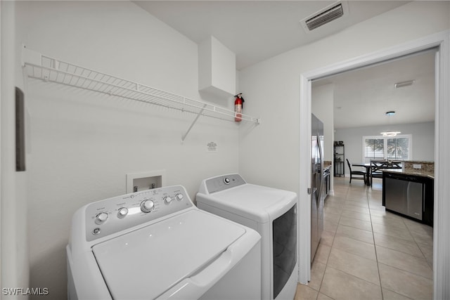 laundry room featuring washer and dryer and light tile patterned flooring