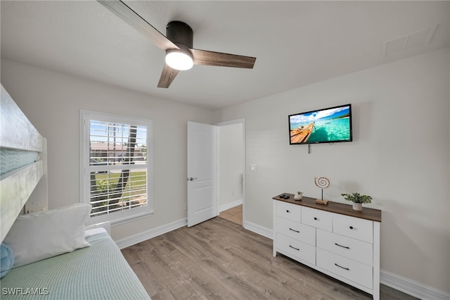 unfurnished room with ceiling fan, light wood finished floors, and baseboards