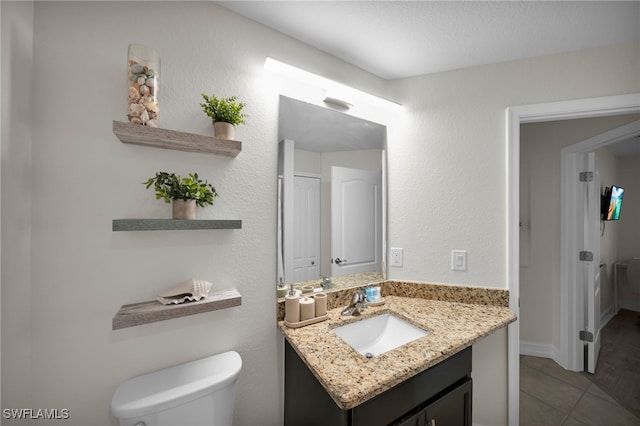 bathroom with toilet, tile patterned flooring, and vanity
