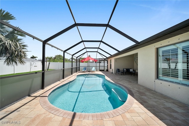 view of pool with a patio and glass enclosure