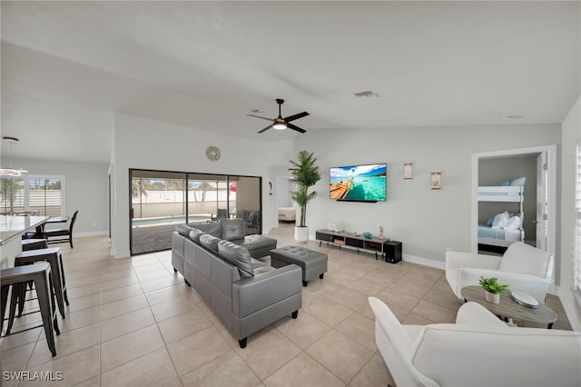 living area featuring light tile patterned floors, ceiling fan, and baseboards