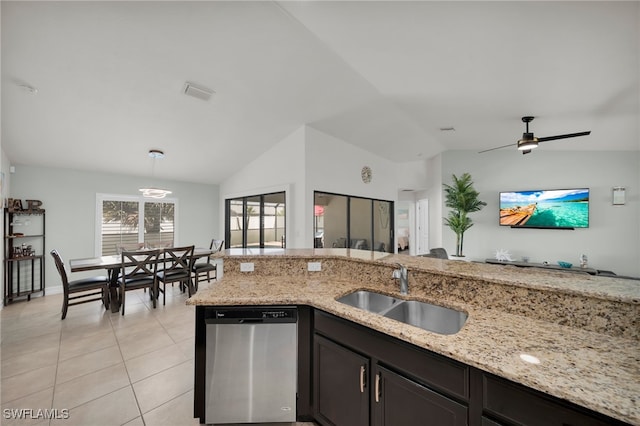 kitchen featuring stainless steel dishwasher, a sink, light tile patterned floors, vaulted ceiling, and light stone countertops