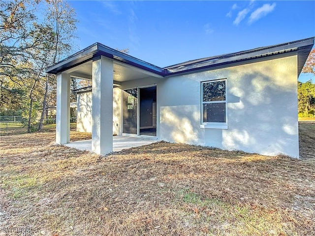 3309 55th St W, Lehigh Acres, FL 33971 - rear view of house with stucco siding and a patio area