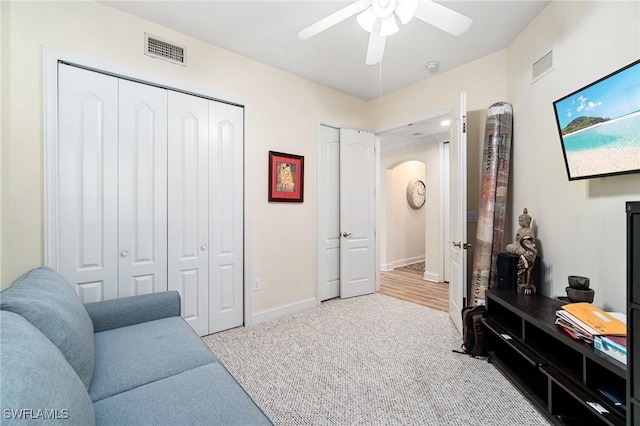 1259 Carpazi Ct Unit 302, Naples, FL 34105 - living room featuring carpet floors, visible vents, a ceiling fan, and arched walkways