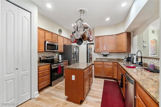 1259 Carpazi Ct Unit 302, Naples, FL 34105 - kitchen with a sink, stone countertops, stainless steel appliances, a kitchen island, and arched walkways
