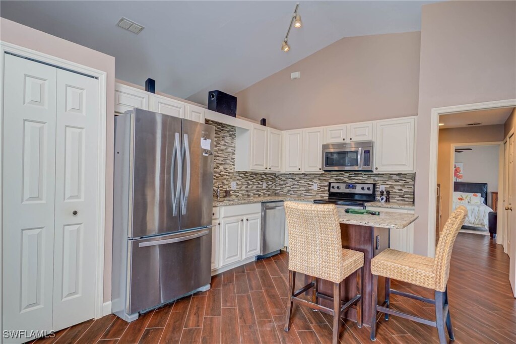 442 Golden Gate Blvd W, Naples, FL 34120 - kitchen featuring visible vents, white cabinets, stainless steel appliances, and decorative backsplash