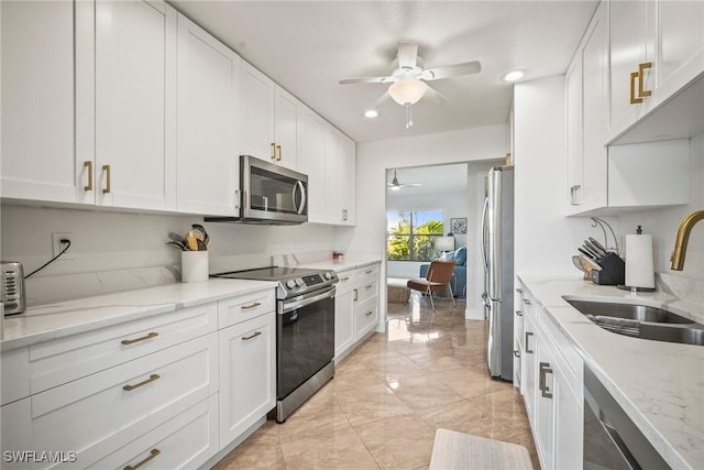 20640 Porthole Ct, Estero, FL 33928 - kitchen with white cabinets, marble finish floor, a ceiling fan, a sink, and appliances with stainless steel finishes