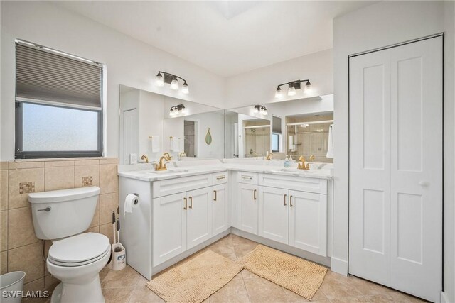 20640 Porthole Ct, Estero, FL 33928 - bathroom featuring double vanity, toilet, a stall shower, tile patterned flooring, and a closet