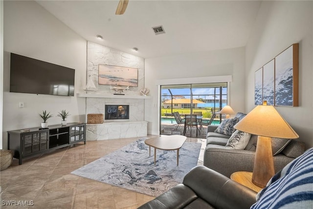 20640 Porthole Ct, Estero, FL 33928 - living area with high vaulted ceiling, a ceiling fan, visible vents, and a premium fireplace