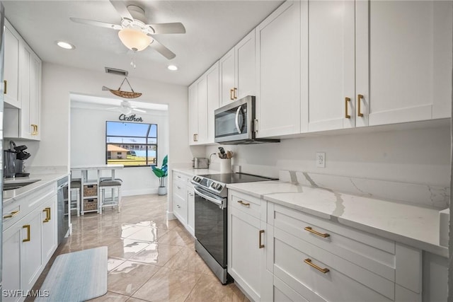 20640 Porthole Ct, Estero, FL 33928 - kitchen featuring white cabinets, recessed lighting, visible vents, light stone countertops, and appliances with stainless steel finishes