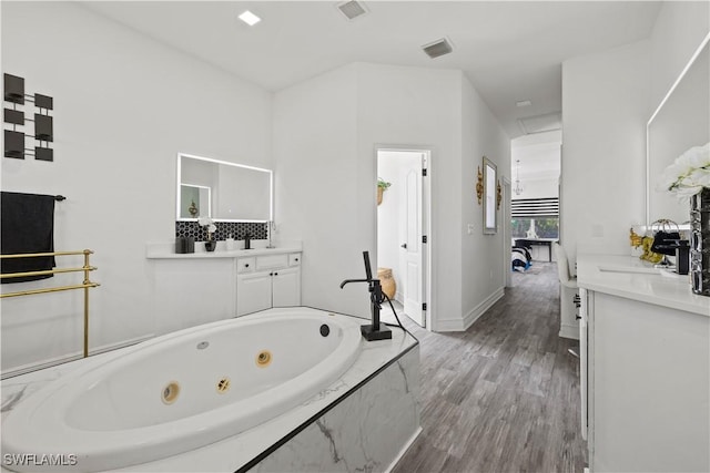 3007 8th St W, Lehigh Acres, FL 33971 - full bath with vanity, a whirlpool tub, wood finished floors, and baseboards