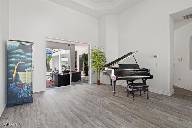3007 8th St W, Lehigh Acres, FL 33971 - sitting room with wood finished floors, baseboards, crown molding, and a towering ceiling