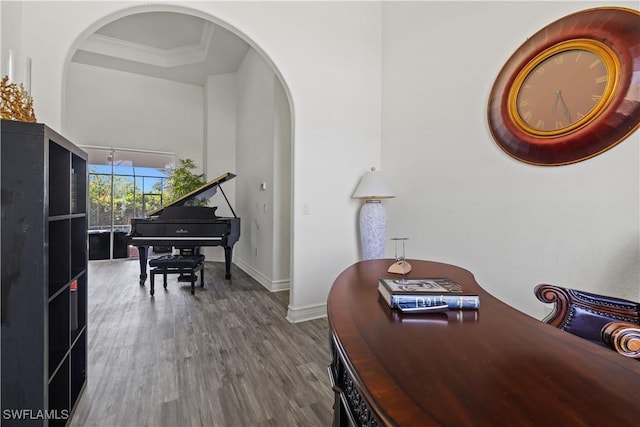 3007 8th St W, Lehigh Acres, FL 33971 - sitting room featuring arched walkways, wood finished floors, baseboards, ornamental molding, and a tray ceiling
