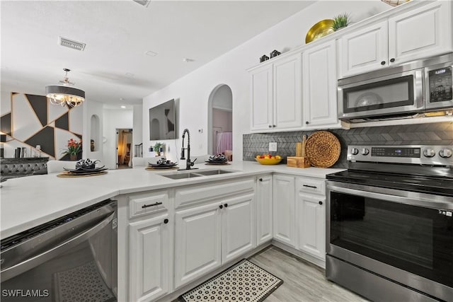 3007 8th St W, Lehigh Acres, FL 33971 - kitchen featuring stainless steel appliances, a sink, arched walkways, and light countertops