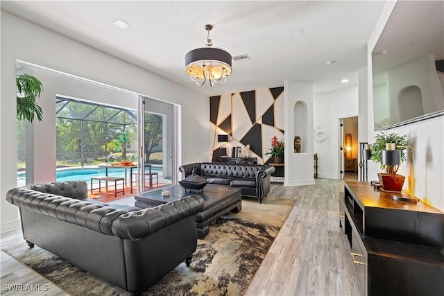 3007 8th St W, Lehigh Acres, FL 33971 - living area with a chandelier, wood finished floors, a sunroom, baseboards, and arched walkways