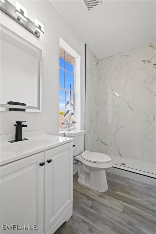 3007 8th St W, Lehigh Acres, FL 33971 - bathroom with vanity, a marble finish shower, toilet, and wood finished floors
