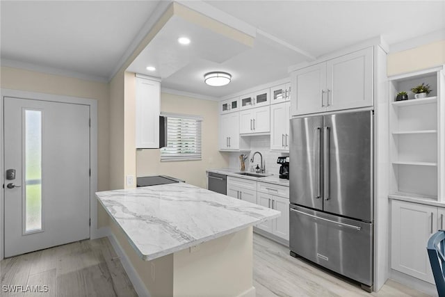 kitchen with white cabinets, light wood-style flooring, appliances with stainless steel finishes, and a sink