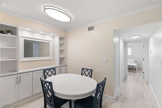 dining area featuring light wood-type flooring, baseboards, and visible vents