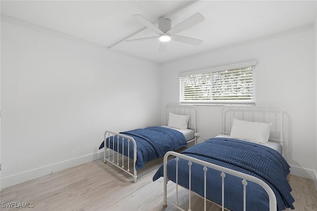 bedroom with wood finished floors, a ceiling fan, and baseboards