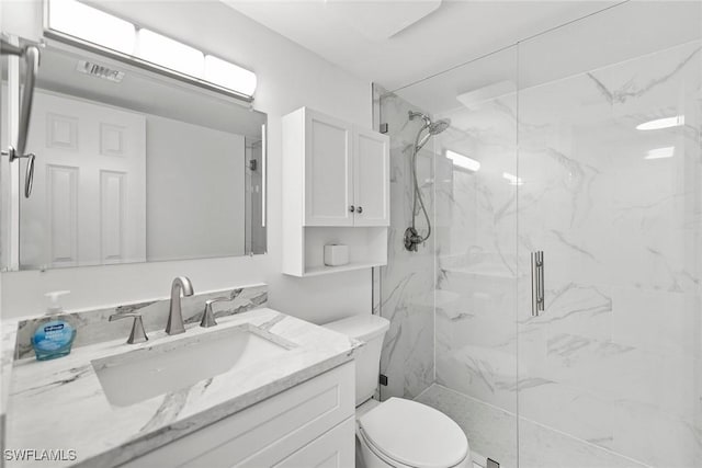 full bathroom featuring visible vents, toilet, vanity, and a marble finish shower