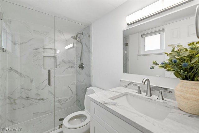 bathroom featuring toilet, vanity, and a marble finish shower