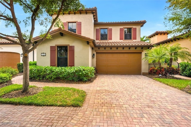 7996 Cordoba Pl, Naples, FL 34113 - mediterranean / spanish-style home featuring stucco siding, decorative driveway, an attached garage, and a tile roof
