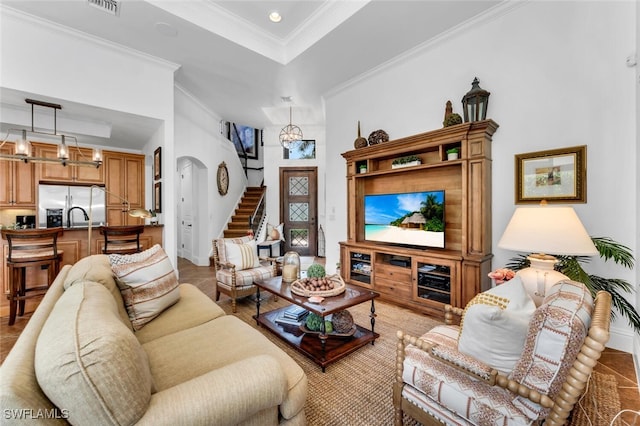 7996 Cordoba Pl, Naples, FL 34113 - living area featuring crown molding, a raised ceiling, arched walkways, stairway, and recessed lighting