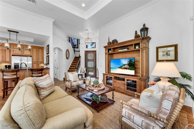 7996 Cordoba Pl, Naples, FL 34113 - living area with crown molding, a tray ceiling, arched walkways, stairs, and recessed lighting