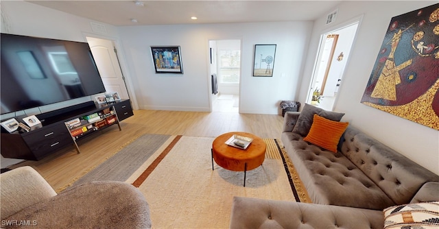 living room featuring wood finished floors, baseboards, and recessed lighting