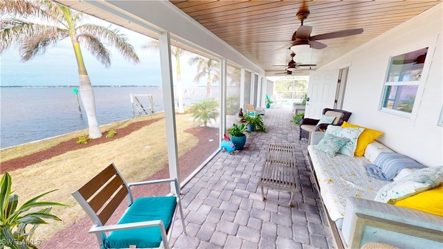 sunroom with a water view, outdoor lounge area, and a ceiling fan