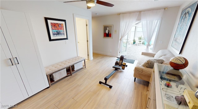 sitting room with a ceiling fan, light wood finished floors, and baseboards