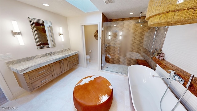 bathroom with a stall shower, toilet, a freestanding bath, recessed lighting, and vanity