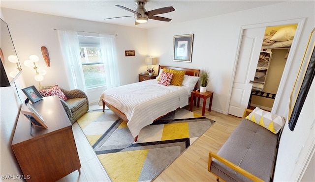 bedroom featuring light wood-style floors, a ceiling fan, and baseboards