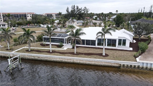 back of property featuring a water view and glass enclosure