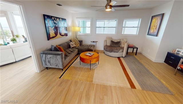 sitting room featuring a ceiling fan, light wood finished floors, and baseboards