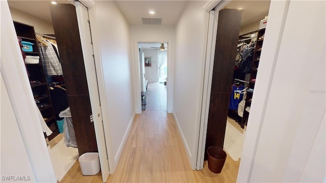 hallway featuring light wood-type flooring, baseboards, and recessed lighting