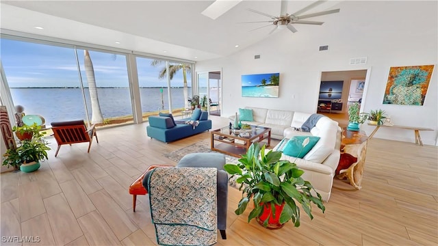 living room featuring light wood finished floors, ceiling fan, high vaulted ceiling, a water view, and recessed lighting