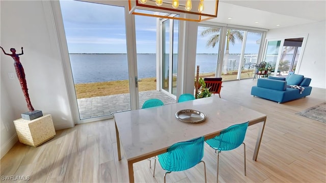 sunroom / solarium with a water view and a chandelier