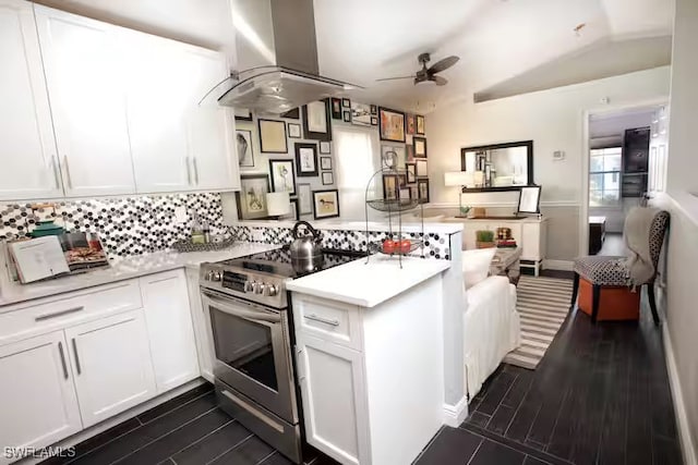 kitchen with a peninsula, white cabinetry, exhaust hood, stainless steel range with electric stovetop, and light countertops
