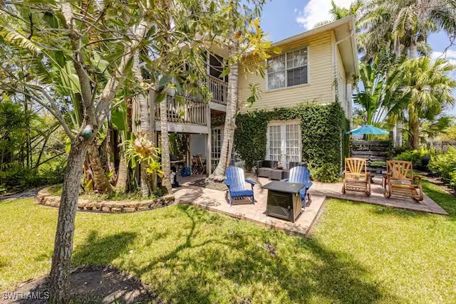 rear view of house with a patio area, a yard, outdoor lounge area, and a balcony