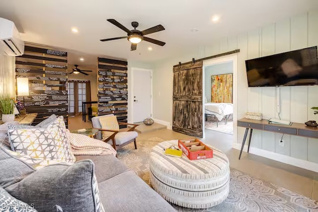 living room with recessed lighting, a barn door, a wall mounted air conditioner, baseboards, and a ceiling fan