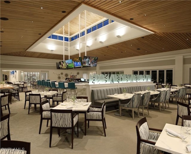 dining space featuring light carpet and wooden ceiling