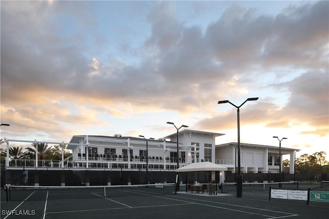 view of tennis court with fence and a gazebo