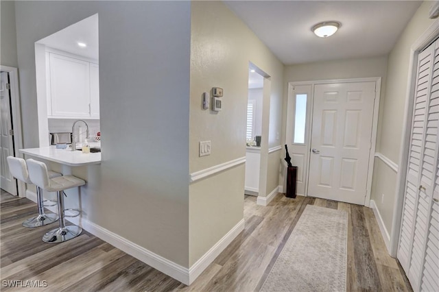 entrance foyer featuring light wood finished floors and baseboards