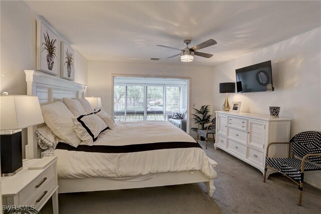 bedroom featuring a ceiling fan, visible vents, and dark carpet