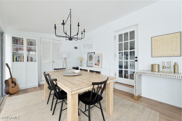 dining area with a chandelier and light wood-style flooring