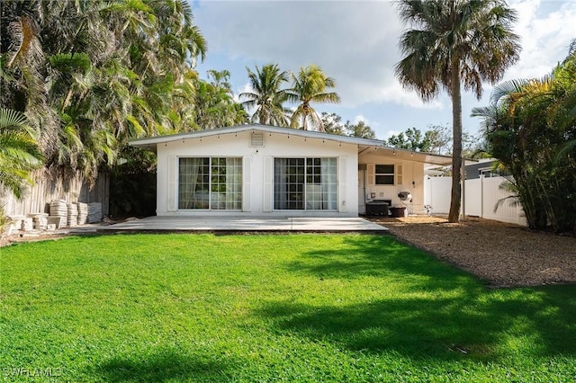 rear view of house with a lawn, a patio, and a fenced backyard