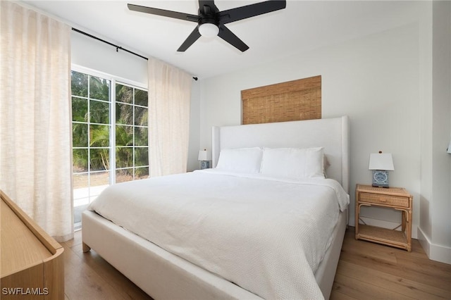 bedroom featuring wood finished floors, access to exterior, baseboards, and ceiling fan