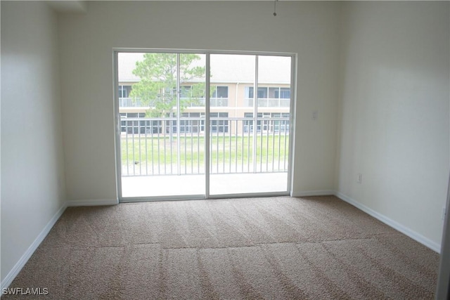 carpeted empty room with baseboards