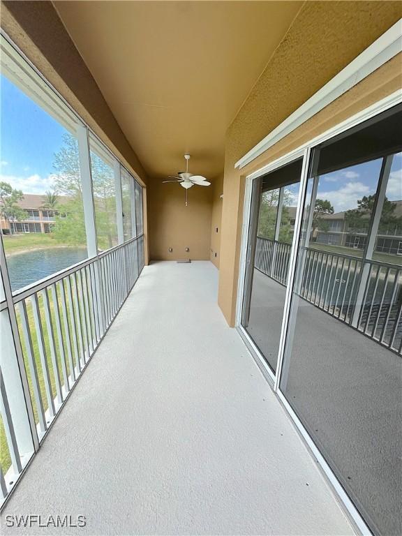 balcony with a water view and ceiling fan